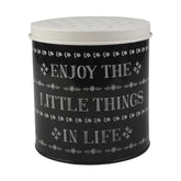 Fémből készült, fekete és fehér színű, motívumokkal és "Enjoy the little things in life" felirattal díszített konyhai tárolódoboz